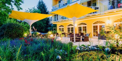 Hotels am See - Liegewiese direkt am See - Kärnten - Außenansicht Terrasse am Abend - Erwachsenenhotel "das Moser - Hotel am See"