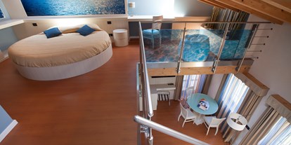 Hotels am See - Fahrstuhl - Gardasee - Verona - Das Paradies existiert und in dieser Suite scheint man auf dem Wasser zu schweben, die Farbe Blau ist hier dominierend.
Penthouse von 45 m² mit großem Wohnzimmer, Schlafzimmer im Dach, 2 Badezimmer (eine von 6/7 m² mit Badewanne mt Dusche und eine von 4/5 m² mit Hydro-Dusche), 1 schönem Balkon (5/6 m²) und 2 Fenster, alle mit Seeblick. - Belfiore Park Hotel