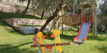 Hotels am See - Balkon - Venetien - Für die Kleinen hingegen ist Spaß auf unserem neu eingerichteten Spielplatz garantiert, so dass auch Eltern ihre Kinder im Schatten der Bäume beaufsichtigen können.  - Hotel Eden Gardasee