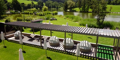 Hotels am See - Fahrstuhl - Österreich - Pergola mit Schwebeliegen und Muschelliegen am Seeufer - Ritzenhof - Hotel und Spa am See