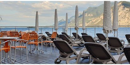 Hotels am See - Verpflegung: Frühstück - Brenzone sul Garda - Terrasse mit Liegestuhle direkt am See, mit Stühlen und Tischen für unsere Bar!  - HOTEL SIRENA