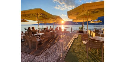 Hotels am See - Abendmenü: Buffet - Gardone Riviera - Beach Bar & Strand-Restaurant
Die Beachbar Dock & Dine serviert italienische Küche, typische Gardasee Gerichte und Meeresfrüchte, die Sie mit einem erfrischenden Cocktail, Bier oder Wein kombinieren können. Genießen Sie unsere Spezialitäten und Sommergetränke beim malerischen Seeblick auf der Open-Air-Terrasse. D&D bietet eine ungezwungene Atmosphäre, die Boardshorts und Flips Flops willkommen heißen! - Taki Village