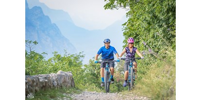 Hotels am See - Abendmenü: mehr als 5 Gänge - Brenzone sul Garda (Verona) - Bike rental & garage

ABENTEUER UND ENTSPANNUNG FÜR IHREN URLAUB

Um Ihren Urlaub zu bereichern, bietet Taki Village einen Support-Desk für Mountainbike-Liebhaber und Leute, die mit ihrem Fahrrad in den Urlaub fahren, und stellt eine kleine, aber gut ausgestattete Garage für die Wartung und Reparatur ihres Fahrrads bereit.

VIELE WEGE - EINEN STANDORT!
Der Gardasee bietet viele Routen für Mountainbike-Liebhaber, alle mit unterschiedlichen Schwierigkeitsgraden, mehreren Pisten, unterschiedlichen Panoramen, aber alle leicht zugänglich!

AUF DER SUCHE NACH DEM ABENTEUER?
Für die Liebhaber der Bergrouten gibt es zahlreiche Möglichkeiten: Monte Baldo, Monte Stivo, Monte Brione und auch das Alto Garda Bresciano oder Monte Bondone Gebiet. Jeder bietet mehrere Strecken, damit Sie einen oder mehrere Tage voller Spaß in der Natur verbringen können!

Hier einige Beispiele:

Monte Baldo Naturpark

Luppia-Crero:
length 30km, height difference 817mt, max slope 18%
Val del Diaol (Downhill):
climb 8km, descent 4,6km, height difference 850mt, needed protections
Coast Trail (Downhill):
climb 10km, descent 7km, height difference 970mt, max slope 17%
Campiano-Monte Fubia:
lenght 18km, height difference 550mt, max slope 20%
Punta Veleno:
length 51km, height difference 1837mt, max slope 20%
Campo di Brenzone:
length 37km, height difference 380mt, max slope 21%
Monte Stivo

S.Barbara Monte Velo Freeride (Downhill)
length 21km, height difference 1072mt, max slope 14%
Malga Zanga - Monte Creino
length 39km, height difference 1233mt, max slope 15%
Bordala
length 48km, height difference 1684mt, max slope 14%
Riva-Arco Area

Riva-Arco Ring + Mount Brione
length 42km, height difference 1062mt, max slope 19%
Laghel-Bagatoli
length 27km, height difference 392mt
Malga Grassi
length 43km, height difference 1075mt, max slope 14%
San Giovanni al Monte
length 40km, height difference 1178mt, max slope 17%
Für weniger unerschrockene Menschen, die jedoch einen anderen Tag am Gardasee verbringen möchten, indem sie Sport treiben und auf der Suche nach schönen Aussichtspunkten sind, bieten das Sarca-Tal, das Etschtal und die Gegend von Arco-Riva besondere Radwege.

Hier einige Beispiele:

Sarca Valley Cycling Route
easy track, 26km, mean slope 1%, max slope 20%
Adige Valley Cycling Route
easy track, 80km, mean slope 1%, max slope 20%
Ledro Valley Cycling Route
easy track, 18km, mean slope 5%, max slope 28%
Ponale (Riva-Ledro) Cycling Route
easy track, 13km, mean slope 5%, max slope 20% - Taki Village