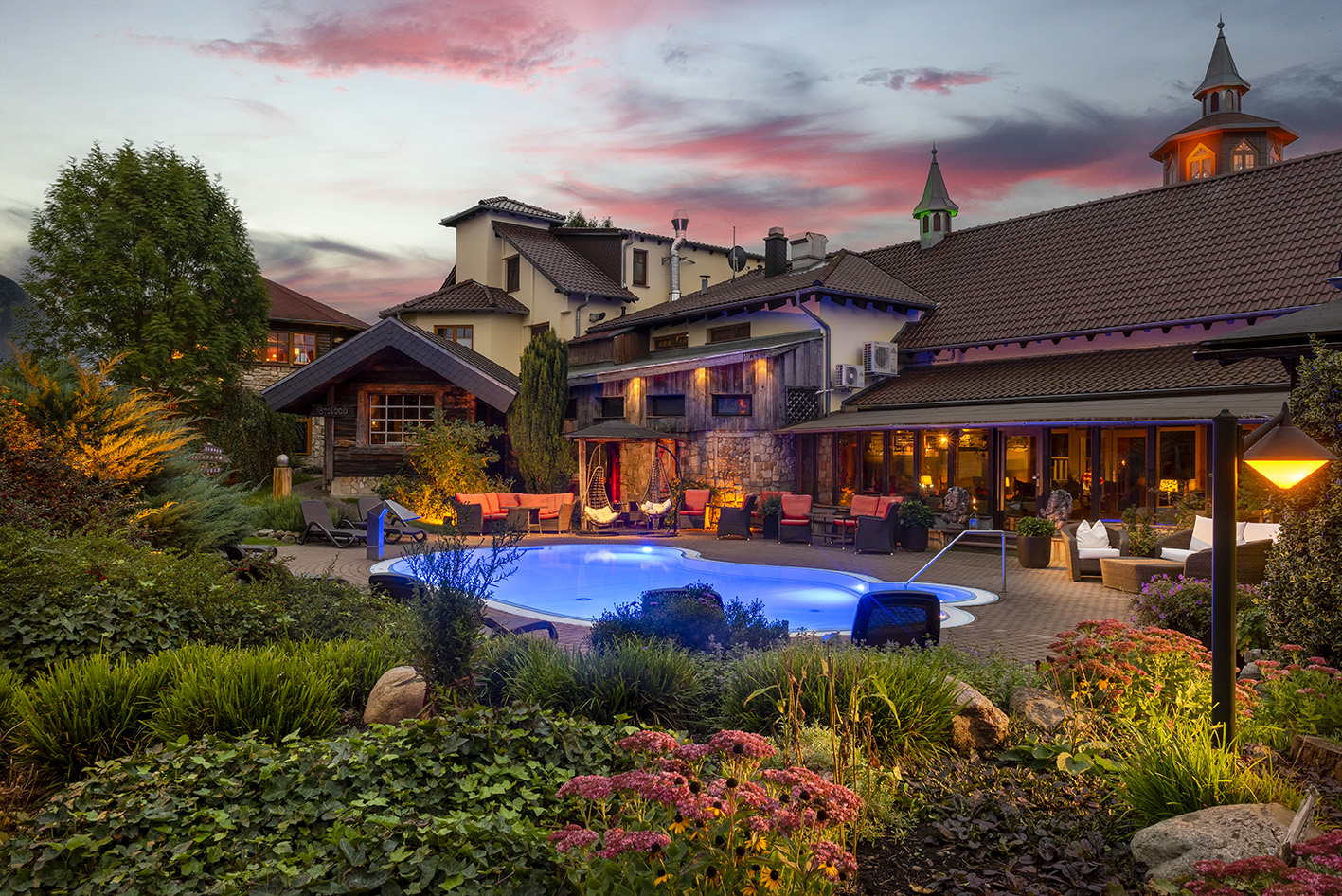 Urlaub am See: Blick auf den beleuchteten Außenpool im Herbst am Abend - Wellnesshotel Seeschlößchen - Privat-SPA & Naturresort