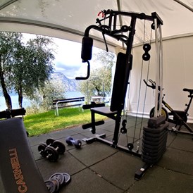 Urlaub am See: Um fit zu bleiben, haben wir ein anständiges Fitnessstudio in unserem Garten. Die wichtigsten Werkzeuge für Ihr körperliches Wohlbefinden finden Sie hier.  - Hotel Eden Gardasee
